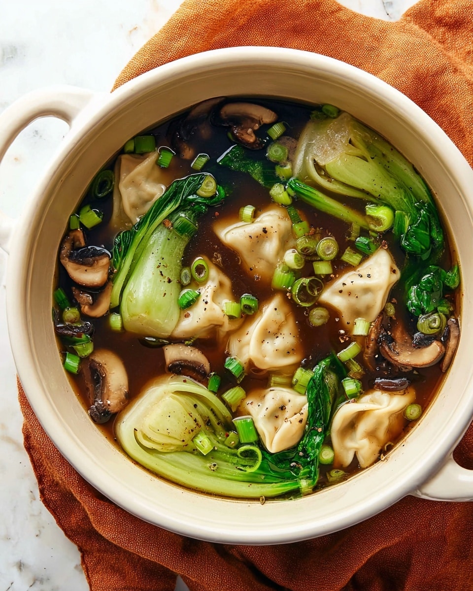 A white pot filled with clear dark brown broth that holds light beige dumplings floating near the top, along with green bok choy leaves and thinly sliced green onions sprinkled throughout. There are also brown shiitake mushroom slices adding texture and color contrast among the dumplings and green vegetables. A metal spoon is dipping into the soup, lifting a couple of dumplings and bok choy. The pot sits on a soft orange cloth on a white marbled surface with some scattered green onion rings beside it. The broth has a few specks of black pepper visible on the dumplings and vegetables. Photo taken with an iphone --ar 4:5 --v 7